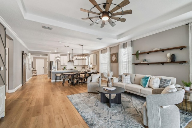 17589 Cruiser Bnd, Land O Lakes, FL 34638 - living room with a tray ceiling, ceiling fan, light wood-style flooring, recessed lighting, and ornamental molding