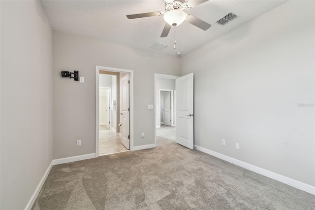 17589 Cruiser Bnd, Land O Lakes, FL 34638 - unfurnished bedroom featuring carpet, baseboards, ensuite bath, a textured ceiling, and ceiling fan