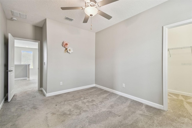 17589 Cruiser Bnd, Land O Lakes, FL 34638 - unfurnished bedroom featuring carpet flooring, a walk in closet, baseboards, and a textured ceiling