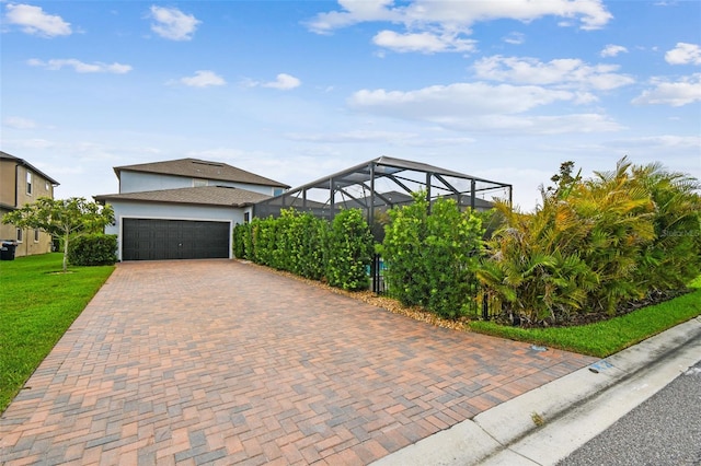 17589 Cruiser Bnd, Land O Lakes, FL 34638 - view of front of home with decorative driveway, an attached garage, a front yard, stucco siding, and glass enclosure