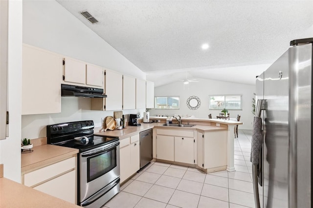 11510 92nd Way, Largo, FL 33773 - kitchen with appliances with stainless steel finishes, under cabinet range hood, lofted ceiling, a peninsula, and a sink