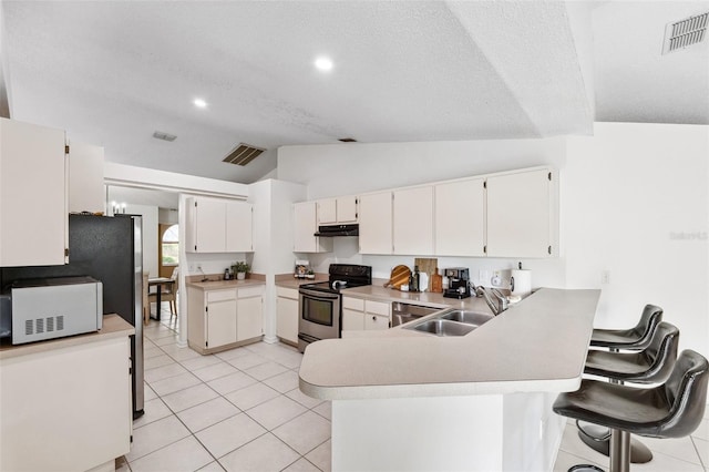 11510 92nd Way, Largo, FL 33773 - kitchen featuring stainless steel appliances, a sink, lofted ceiling, a peninsula, and light tile patterned floors