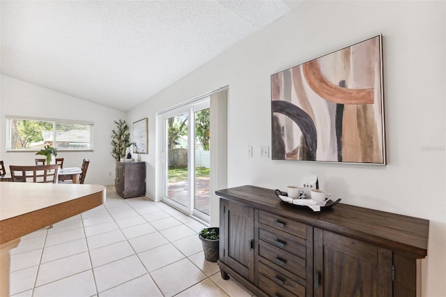 11510 92nd Way, Largo, FL 33773 - dining room featuring plenty of natural light, vaulted ceiling, light tile patterned floors, and a textured ceiling