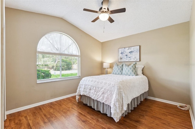 11510 92nd Way, Largo, FL 33773 - bedroom with baseboards, wood finished floors, vaulted ceiling, a textured ceiling, and ceiling fan
