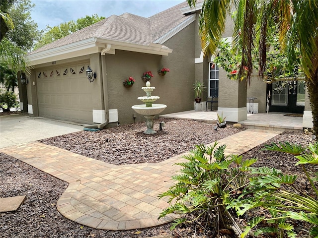 4808 Jewell Ter, Palm Harbor, FL 34685 - view of property exterior featuring stucco siding, concrete driveway, a garage, and roof with shingles