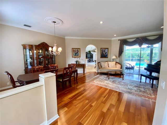 4808 Jewell Ter, Palm Harbor, FL 34685 - dining area featuring arched walkways, wood finished floors, ornamental molding, and a chandelier