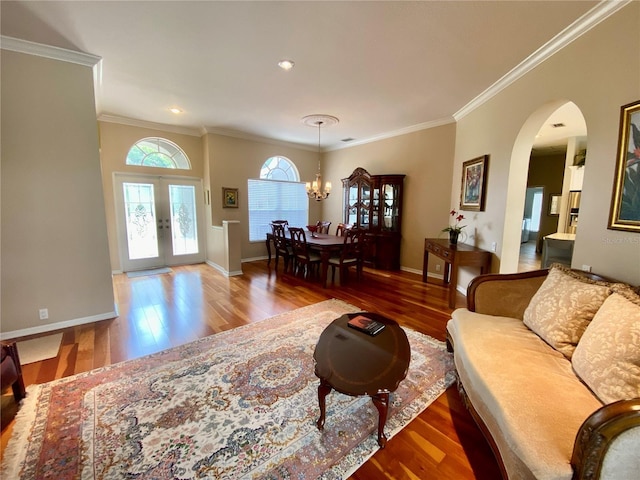 4808 Jewell Ter, Palm Harbor, FL 34685 - living room featuring wood finished floors, ornamental molding, a chandelier, arched walkways, and baseboards