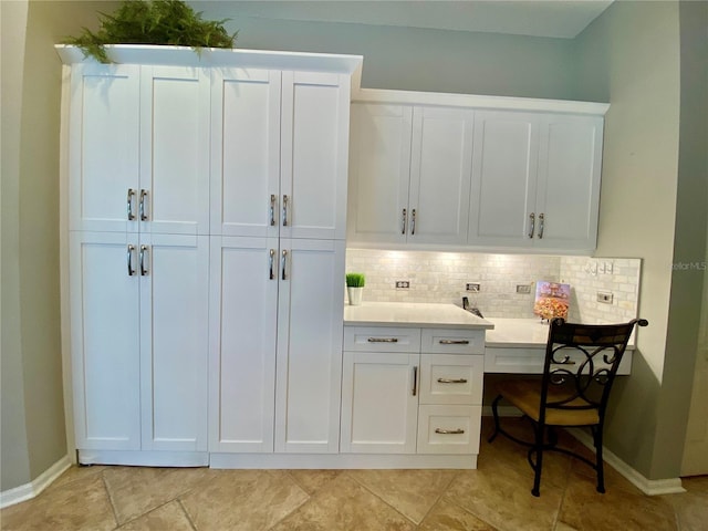 4808 Jewell Ter, Palm Harbor, FL 34685 - kitchen featuring decorative backsplash, baseboards, white cabinets, and light countertops