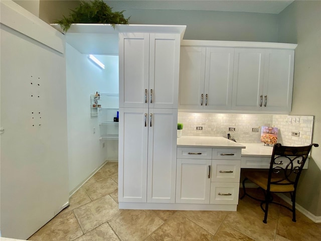 4808 Jewell Ter, Palm Harbor, FL 34685 - kitchen featuring white cabinetry, backsplash, light countertops, and baseboards