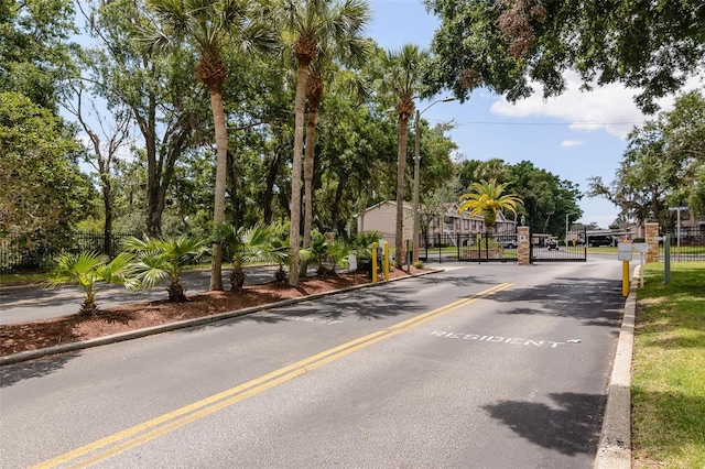 6334 Spring Flower Dr Unit 24, New Port Richey, FL 34653 - view of asphalt road with a gate, curbs, street lighting, and a gated entry