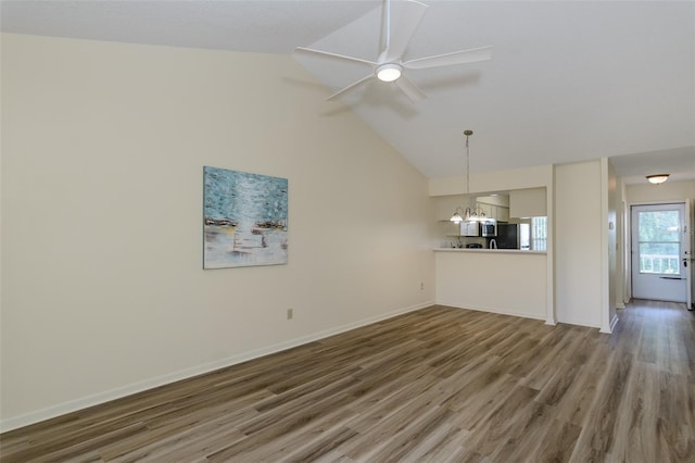 6334 Spring Flower Dr Unit 24, New Port Richey, FL 34653 - unfurnished living room with wood finished floors, a chandelier, ceiling fan, baseboards, and high vaulted ceiling