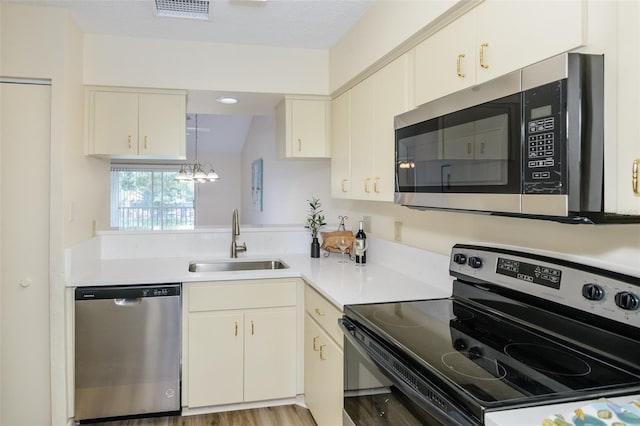 6334 Spring Flower Dr Unit 24, New Port Richey, FL 34653 - kitchen with stainless steel appliances, a sink, light countertops, and a chandelier