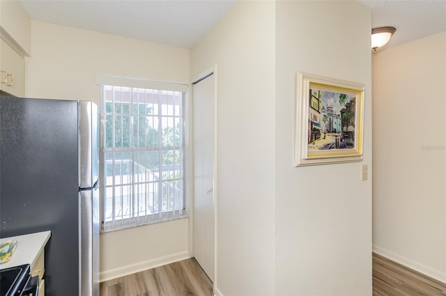 6334 Spring Flower Dr Unit 24, New Port Richey, FL 34653 - kitchen with freestanding refrigerator, wood finished floors, range with electric cooktop, and baseboards