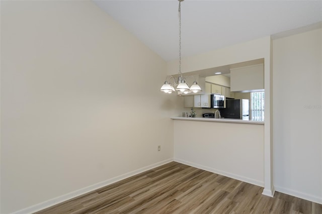 6334 Spring Flower Dr Unit 24, New Port Richey, FL 34653 - unfurnished dining area with wood finished floors, a chandelier, baseboards, and lofted ceiling