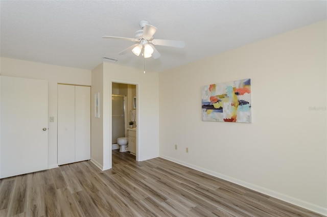 6334 Spring Flower Dr Unit 24, New Port Richey, FL 34653 - unfurnished bedroom featuring wood finished floors, baseboards, a closet, connected bathroom, and ceiling fan