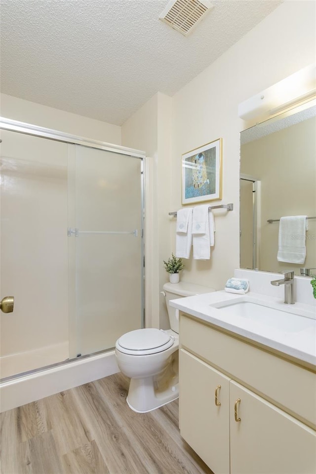 6334 Spring Flower Dr Unit 24, New Port Richey, FL 34653 - full bathroom with wood finished floors, vanity, toilet, a shower stall, and a textured ceiling