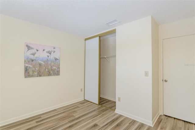 6334 Spring Flower Dr Unit 24, New Port Richey, FL 34653 - unfurnished bedroom featuring light wood finished floors, a closet, and baseboards