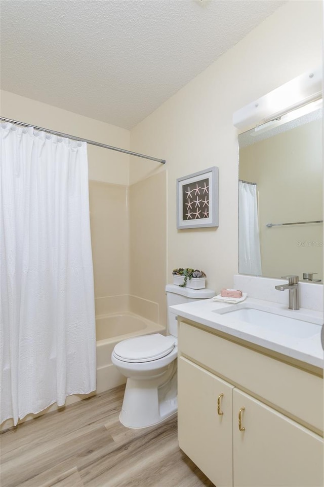 6334 Spring Flower Dr Unit 24, New Port Richey, FL 34653 - full bath featuring vanity, wood finished floors, toilet, shower / bath combo, and a textured ceiling