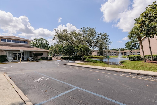 6334 Spring Flower Dr Unit 24, New Port Richey, FL 34653 - view of asphalt road featuring a water view, sidewalks, and curbs