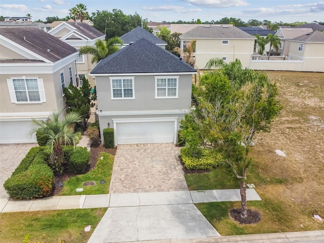 7523 Excitement Dr, Kissimmee, FL 34747 - traditional-style home featuring driveway, stucco siding, a residential view, a shingled roof, and a garage