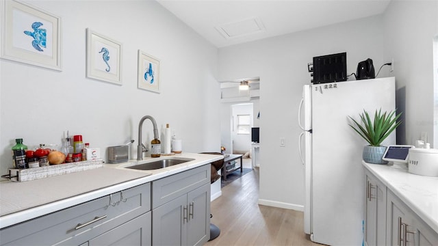 1615 28th Ave N, Saint Petersburg, FL 33713 - kitchen featuring a sink, gray cabinetry, freestanding refrigerator, light wood finished floors, and light countertops