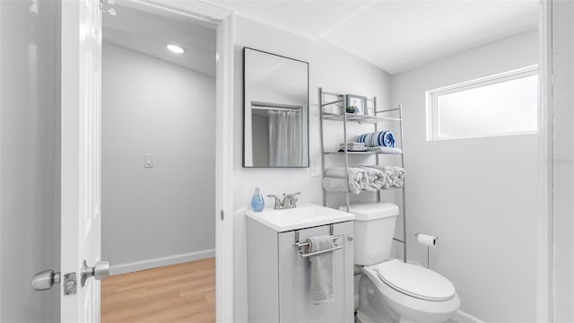 1615 28th Ave N, Saint Petersburg, FL 33713 - bathroom with toilet, vanity, wood finished floors, and baseboards