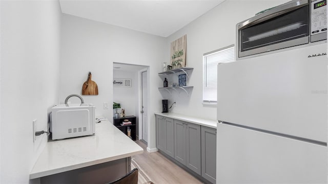 1615 28th Ave N, Saint Petersburg, FL 33713 - kitchen featuring freestanding refrigerator, gray cabinetry, open shelves, and light wood-style floors