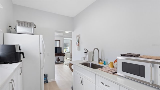 1615 28th Ave N, Saint Petersburg, FL 33713 - kitchen featuring white appliances, a sink, light wood-style floors, light countertops, and white cabinetry