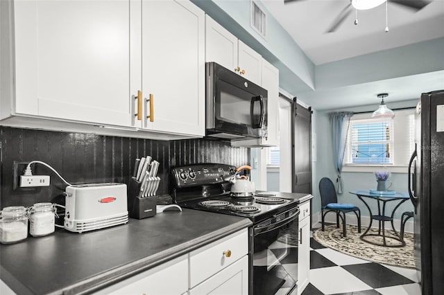 634 6th St N, Saint Petersburg, FL 33701 - kitchen with black appliances, tile patterned floors, white cabinets, backsplash, and a barn door