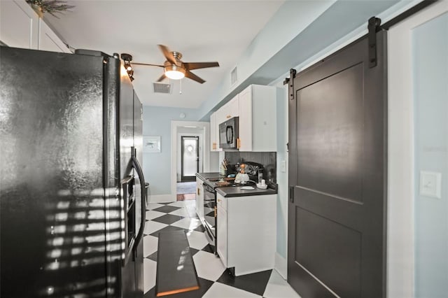 634 6th St N, Saint Petersburg, FL 33701 - kitchen featuring black appliances, a barn door, tile patterned floors, dark countertops, and white cabinets