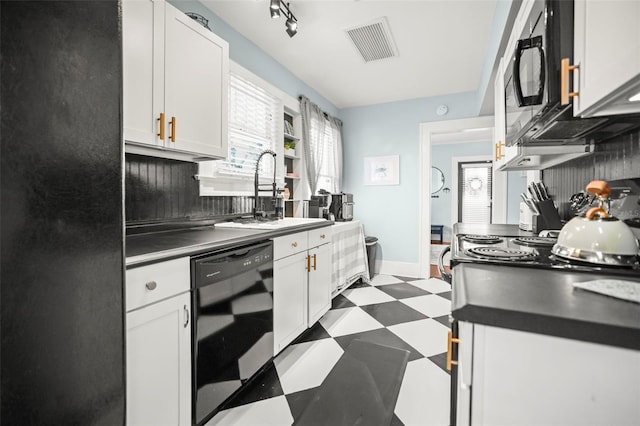 634 6th St N, Saint Petersburg, FL 33701 - kitchen with black appliances, dark flooring, a sink, white cabinets, and dark countertops