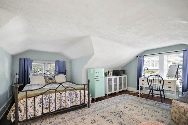 634 6th St N, Saint Petersburg, FL 33701 - bedroom with vaulted ceiling, a textured ceiling, baseboards, and wood finished floors