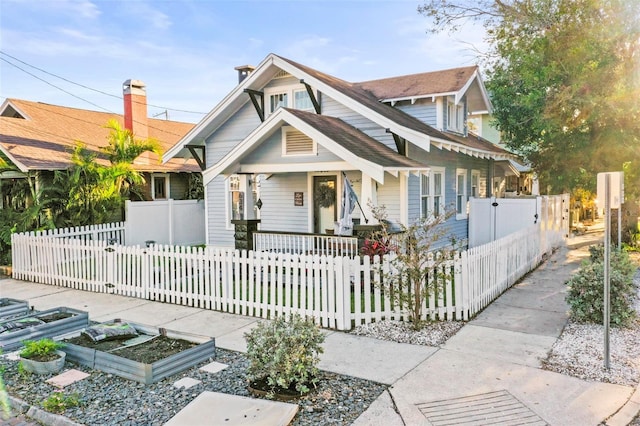 634 6th St N, Saint Petersburg, FL 33701 - view of front of home featuring a porch, a garden, and a fenced front yard