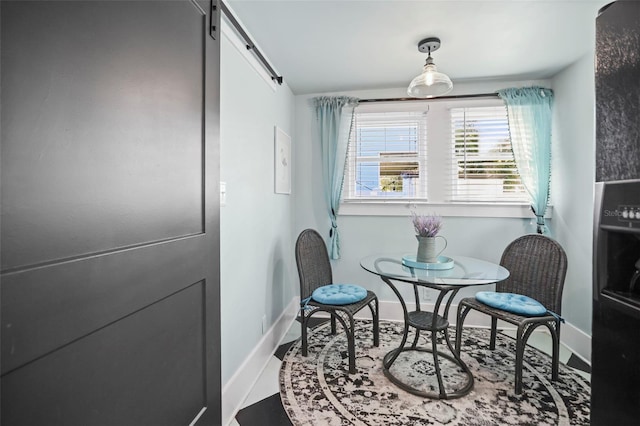 634 6th St N, Saint Petersburg, FL 33701 - dining room featuring a barn door and baseboards