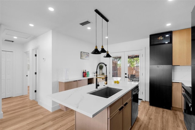 1851 Oklahoma Ave NE, Saint Petersburg, FL 33703 - kitchen featuring a sink, light wood finished floors, dishwasher, an island with sink, and pendant lighting