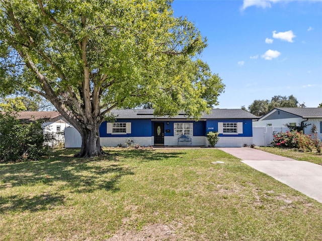 2426 17th Ave N, Saint Petersburg, FL 33713 - view of front facade with solar panels, driveway, and concrete block siding