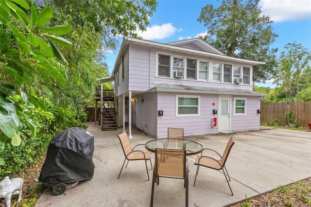 1115 Highland St N, Saint Petersburg, FL 33701 - back of property with stairway, a patio, cooling unit, and outdoor dining area