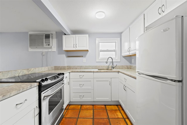 1115 Highland St N, Saint Petersburg, FL 33701 - kitchen featuring freestanding refrigerator, stainless steel electric range oven, a sink, a wall mounted air conditioner, and white cabinetry