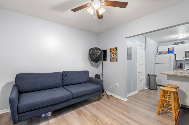 1115 Highland St N, Saint Petersburg, FL 33701 - living room with light wood-type flooring, a ceiling fan, baseboards, and electric panel