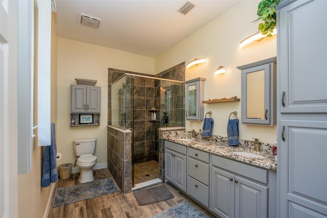 14365 Evans Ranch Rd, Lakeland, FL 33809 - bathroom with double vanity, a shower stall, toilet, and wood tiled floors