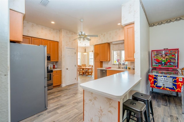 14365 Evans Ranch Rd, Lakeland, FL 33809 - kitchen with stainless steel appliances, a peninsula, light wood-style floors, ceiling fan, and wallpapered walls