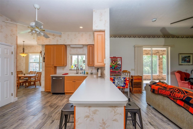 14365 Evans Ranch Rd, Lakeland, FL 33809 - kitchen featuring a kitchen breakfast bar, ceiling fan, dishwasher, light countertops, and light wood-type flooring