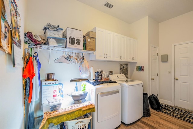 14365 Evans Ranch Rd, Lakeland, FL 33809 - laundry area featuring separate washer and dryer, cabinet space, and wood finished floors