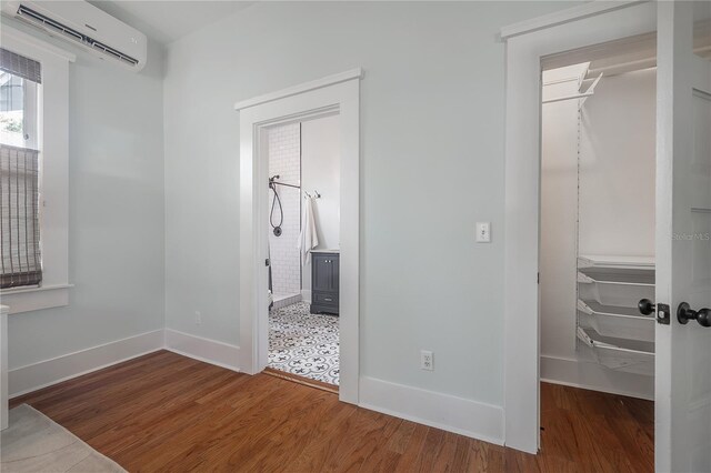 5301 N Central Ave, Tampa, FL 33603 - unfurnished bedroom featuring a wall mounted AC, wood finished floors, baseboards, and a closet
