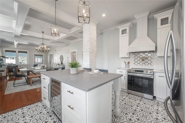 5301 N Central Ave, Tampa, FL 33603 - kitchen with appliances with stainless steel finishes, open floor plan, decorative columns, premium range hood, and tasteful backsplash