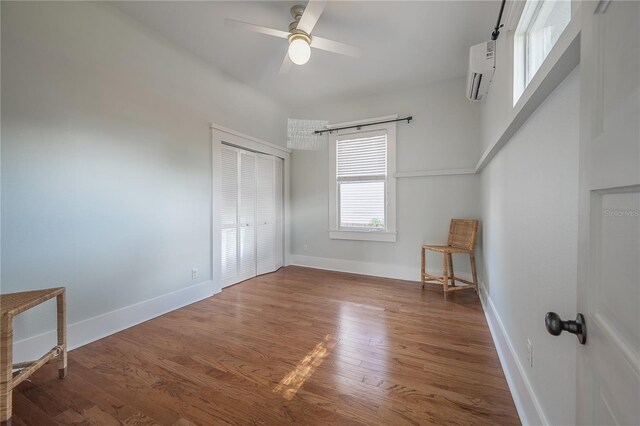 5301 N Central Ave, Tampa, FL 33603 - unfurnished bedroom with a wall mounted air conditioner, wood finished floors, a closet, baseboards, and ceiling fan