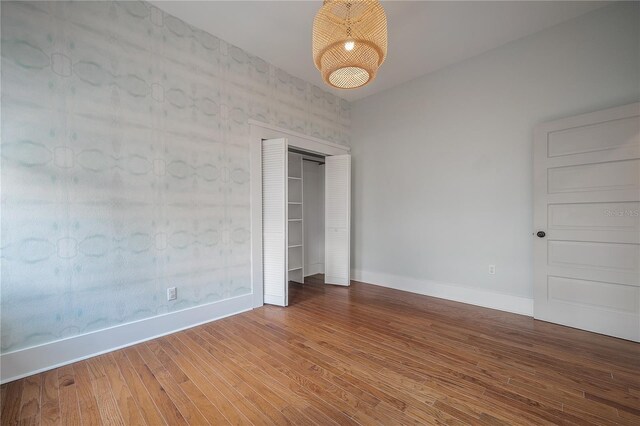 5301 N Central Ave, Tampa, FL 33603 - unfurnished bedroom with wood finished floors, baseboards, a chandelier, and a closet