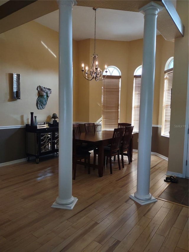 6615 Vanda Ln, Land O Lakes, FL 34637 - dining area with decorative columns, wood finished floors, a chandelier, and baseboards