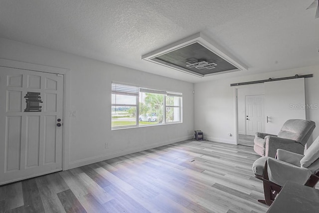 1816 W Lake Parker Dr, Lakeland, FL 33805 - sitting room with a barn door, wood finished floors, baseboards, and a textured ceiling
