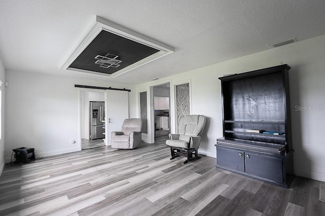 1816 W Lake Parker Dr, Lakeland, FL 33805 - living area featuring a barn door, wood finished floors, and baseboards